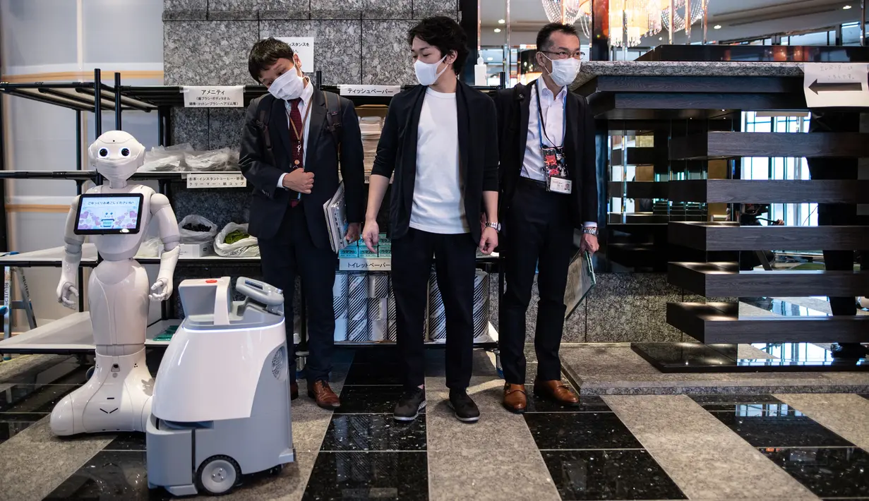 Robot Pepper (kiri) dan Whiz (kedua kiri) berdiri di lobi hotel yang diubah menjadi lokasi karantina pasien COVID-19, Tokyo, Jepang, Jumat (1/5/2020). Hingga 30 April 2020, jumlah kasus COVID-19 di Jepang telah lebih dari 14 ribu orang positif dan 448 meninggal. (Philip FONG/AFP)