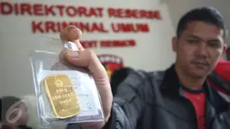 Petugas menunjukan barang bukti emas batangan dalam rilis di Polda Metro Jaya, Jakarta, Jumat (17/2). Empat kasus tersebut di usut selama periode Februari 2017 dengan mengamankan 11 orang tersangka. (Liputan6.com/Immanuel Antonius)