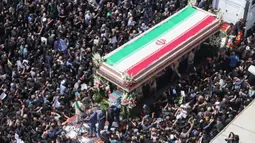 Kerumunan besar warga Iran terlihat memadati jalan-jalan di ibu kota Teheran untuk mengikuti prosesi pemakaman Presiden Ebrahim Raisi yang meninggal dunia dalam kecelakaan helikopter pada Minggu (19/5/2024). (ATTA KENARE/AFP)