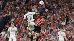 Pemain Real Madrid, Jude Bellingham, berebut bola dengan pemain Athletic Bilbao, Inigo Ruiz, pada laga pekan ke-1 La Liga 2023/2024 di Stadion San Mames, Minggu (13/8/2023). Los Blancos menang dengan skor 2-0. (AP Photo/Alvaro Barrientos)