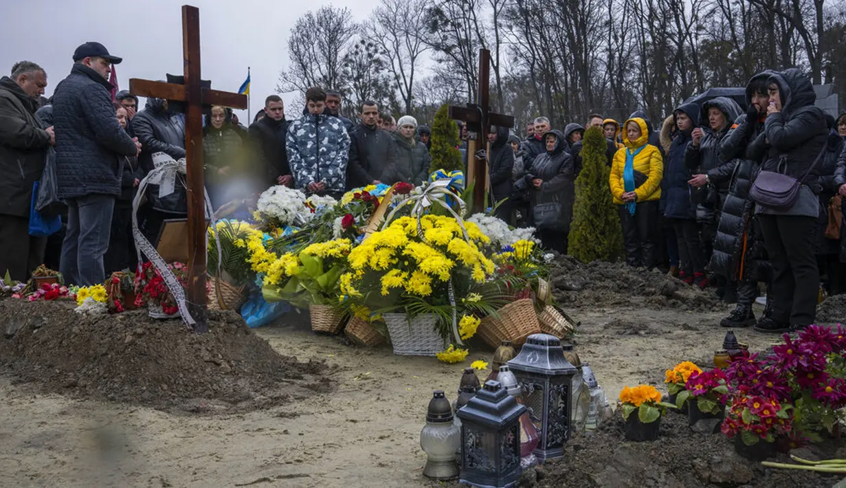 Keluarga dan teman menghadiri pemakaman Sersan Kostiv Andrew (37) yang tewas dalam perang dengan Rusia di pemakaman Lychakiv, Lviv, Ukraina, Selasa (5/4/2022). (AP Photo/Nariman El-Mofty)