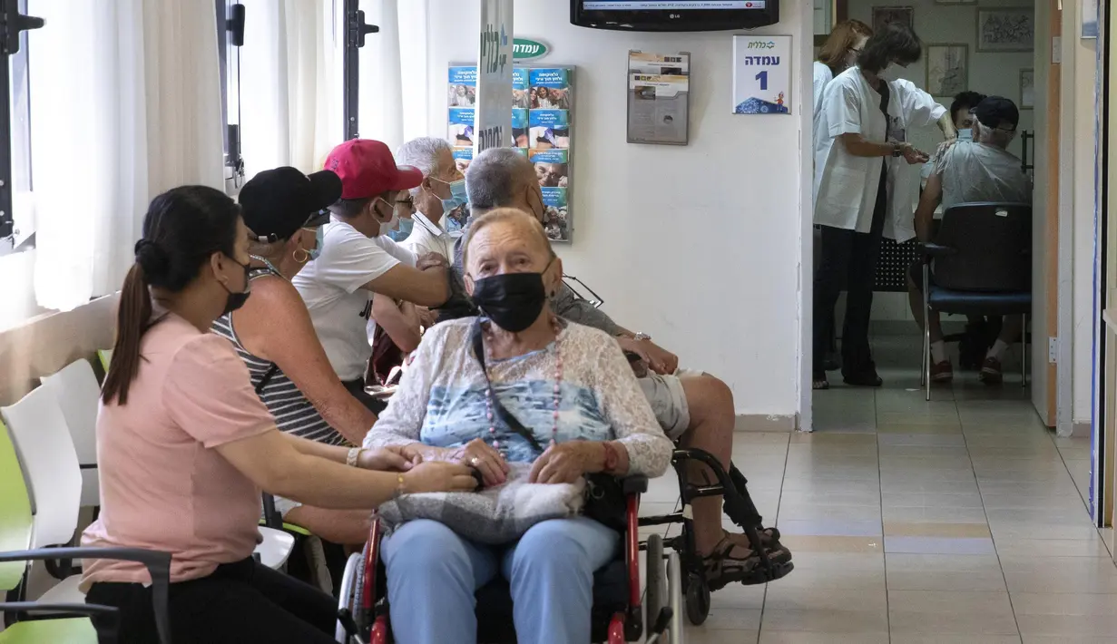 Warga Israel mengantre saat seorang pria menerima dosis ketiga vaksin COVID-19 Pfizer-BioNTech di Tel Aviv, Minggu (1/8/2021). Israel pada 29 Juli 2021 memulai kampanye dosis vaksin Covid-19 ketiga untuk warga berusia 60 tahun ke atas. (AP Photo/Sebastian Scheiner)