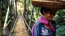 Seorang nenek Baduy Luar dengan membawa sair di kepala melintasi jembatan bambu menuju Kampung Marengo, Kabupaten Lebak, Banten, Jumat (13/05). (Liputan6.com/Fery Pradolo)