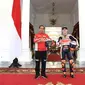 Presiden Joko Widodo berfoto dengan pembalap Repsol Honda, Pol Espargaro di Istana Merdeka, Jakarta, Rabu (16/3/2022). Para pembalap datang dengan memakai setelah baju khusus balap motor yang akan dipakai dalam Grand Prix Indonesia di Mandalika pada 20 Maret 2022 (Lukas - Biro Pers/Setpres)