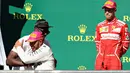 Pembalap Marcedes, Lewis Hamilton memeluk mantan atlet lari cepat asal Jamaika, Usain Bolt saat mendapat ucapan selamat di atas podium GP Amerika Serikat di Circuit of Americas, Minggu (22/10). (MARK THOMPSON / GETTY IMAGES / AFP)