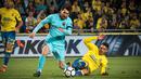 Pemain Barcelona Lionel Messi berebut bola dengan bek Las Palmas, Ximo Navarro Jimenez pada jornada ke-26 La Liga 2017-2018 di Estadio Gran Canaria, Kamis (1/3). Barcelona gagal menang karena tuan rumah menahan imbang dengan skor 1-1. (DESIREE MARTIN/AFP)