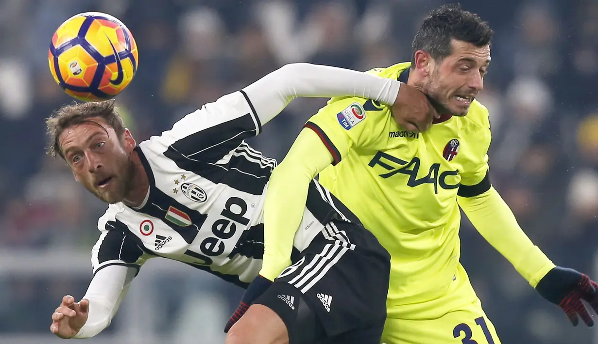 Duel pemain Juventus, Claudio Marchisio (kiri) dengan pemain Bologna, Blerim Dzemaili pada laga Serie A di Juventus Stadium, Turin, (8/1/2017). Juventus menang 3-0. (AFP/Marco Bertorello)