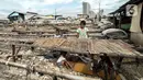 Anak-nak nelayan bermain dekat jemuran ikan asin yang tidak terpakai di Muara Angke, Jakarta, Minggu (8/11/2020). Pandemi Covid-19 dan masuknya musim penghujan di Jakarta menyebabkan permintaan sekaligus produksi ikan asin di Muara Angke merosot hingga 50 persen. (merdeka.com/Iqbal Septian Nugroho)