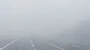 Orang-orang berjalan di Lapangan Merah tanpa terlihat Menara Spasskaya dan Katedral St. Basil tertutup kabut di Moskow, Rusia, Selasa (2/11/2021).  Kabut tebal menyelimuti ibu kota Rusia pada Selasa, menyebabkan banyak penundaan penerbangan di bandara Moskow. (AP Photo/Pavel Golovkin)