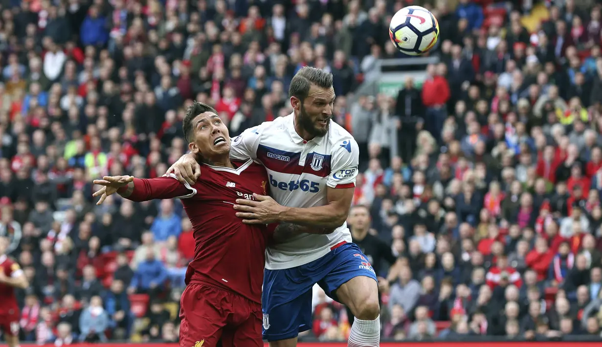 Pemain Liverpool, Roberto Firmino (kiri) berebut bola dengan pemain Stoke City, Erik Pieters pada lanjutan Premier League di Anfield, Liverpool, (28/4/2018). Liverpool hanya bermain imbang 0-0 melawan Stoke City. (Martin Rickett/PA via AP)
