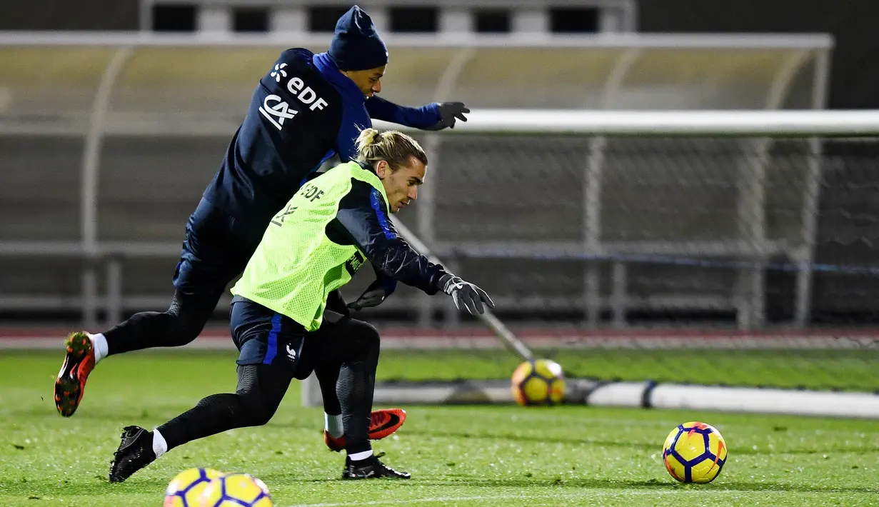 Striker Prancis, Kylian Mbappe dan Antoine Griezmann, berebut bola saat sesi latihan jelang laga persahabatan di Paris, Selasa (7/11/2017). Prancis akan berhadapan dengan Jerman dan Wales. (AFP/Franck Fife)