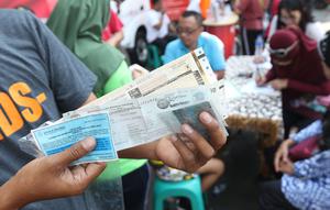 Warga menunjukkan STNK yang baru diperpanjang di gerai Samsat Keliling Car Free Day, Jakarta, Minggu (21/10). Layanan pembayaran pajak Surat Tanda Nomor Kendaraan (STNK) bisa dilakukan tanpa membawa salinan atau BPKB. (Liputan6.com/Angga Yuniar)