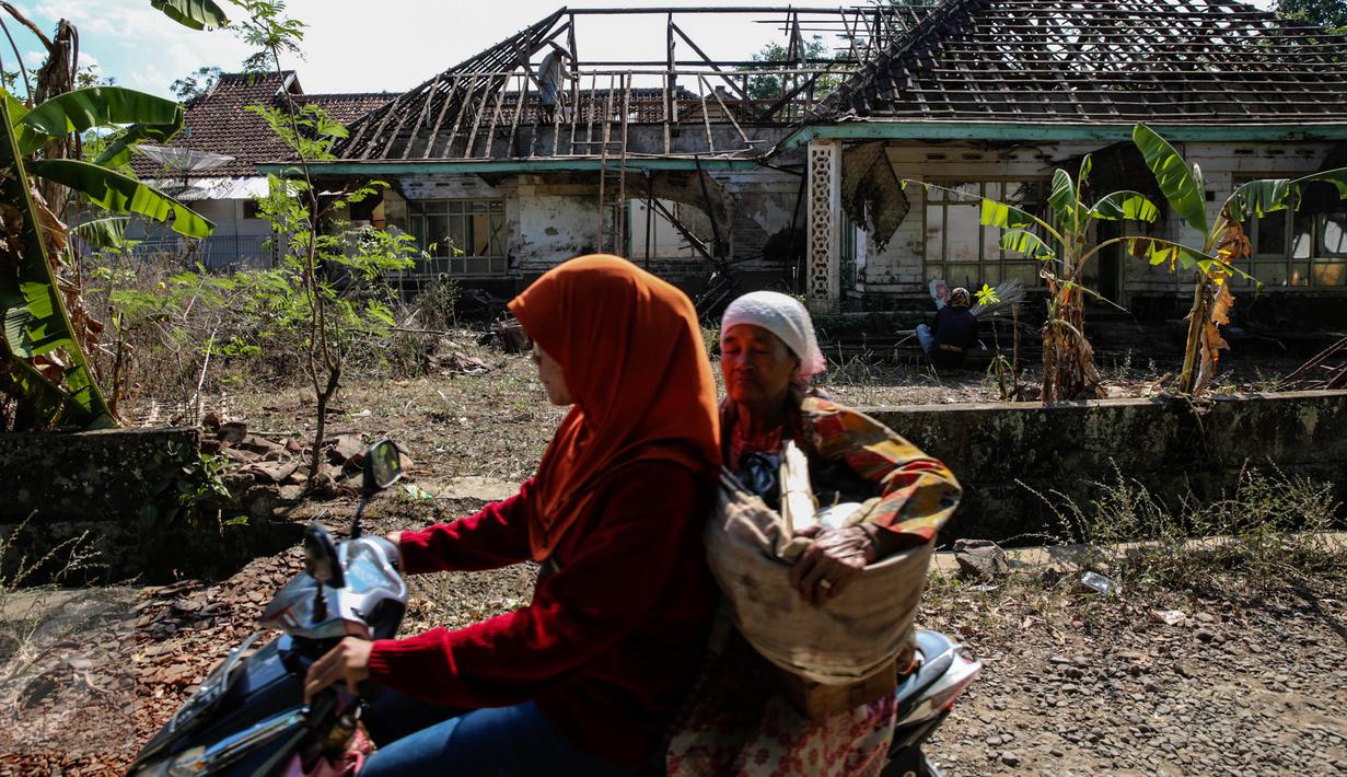 Warga melintas di depan rumah yang akan terkena dampak penggenangan Waduk Jatigede di Desa Cipaku, Sumedang, Jawa Barat, Senin (31/8/2015). Beberapa warga masih ada yang bertahan karena belum tuntasnya soal ganti rugi. (Liputan6.com/Faizal Fanani)