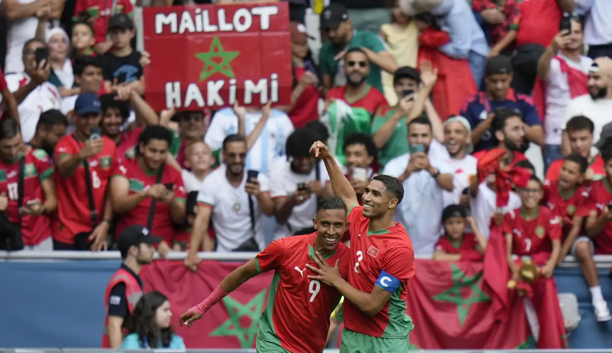 Pemain Maroko, Soufiane Rahimi bersama Achraf Hakimi, melakukan selebrasi setelah mencetak gol ke gawang Argentina pada laga pertama grup B Olimpiade 2024 di stadion Geoffroy-Guichard, Rabu (24/7/2024). (AP Photo/Silvia Izquierdo)