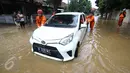 Petugas Damkar PB mendorong mobil terendam banjir di permukiman Bukit Duri, Jakarta, Kamis (16/2). Meluapnya Bendungan Katulampa, Bogor, menyebabkan permukiman kawasan Bukit Duri tergenang air dengan ketinggian 10 - 80 cm. (Liputan6.com/Helmi Afandi)