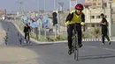Seorang pengendara sepeda muda berkonsentrasi di jalan saat mengikuti perlombaan lokal, di jalan tepi laut di Kota Gaza, Rabu (30/6/2021).  Acara itu bertujuan untuk menciptakan pembebasan mental bagi warga Gaza setelah serangan Israel pada Mei. (AP Photo/Adel Hana)