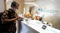 Nasabah BSI mengambil uang dollar usai  layanan ATM antar bank telah Kembali pulih di Gedung Wisma Mandiri I di Jakarta , Kamis (11/05/2023). (Liputan6.com)