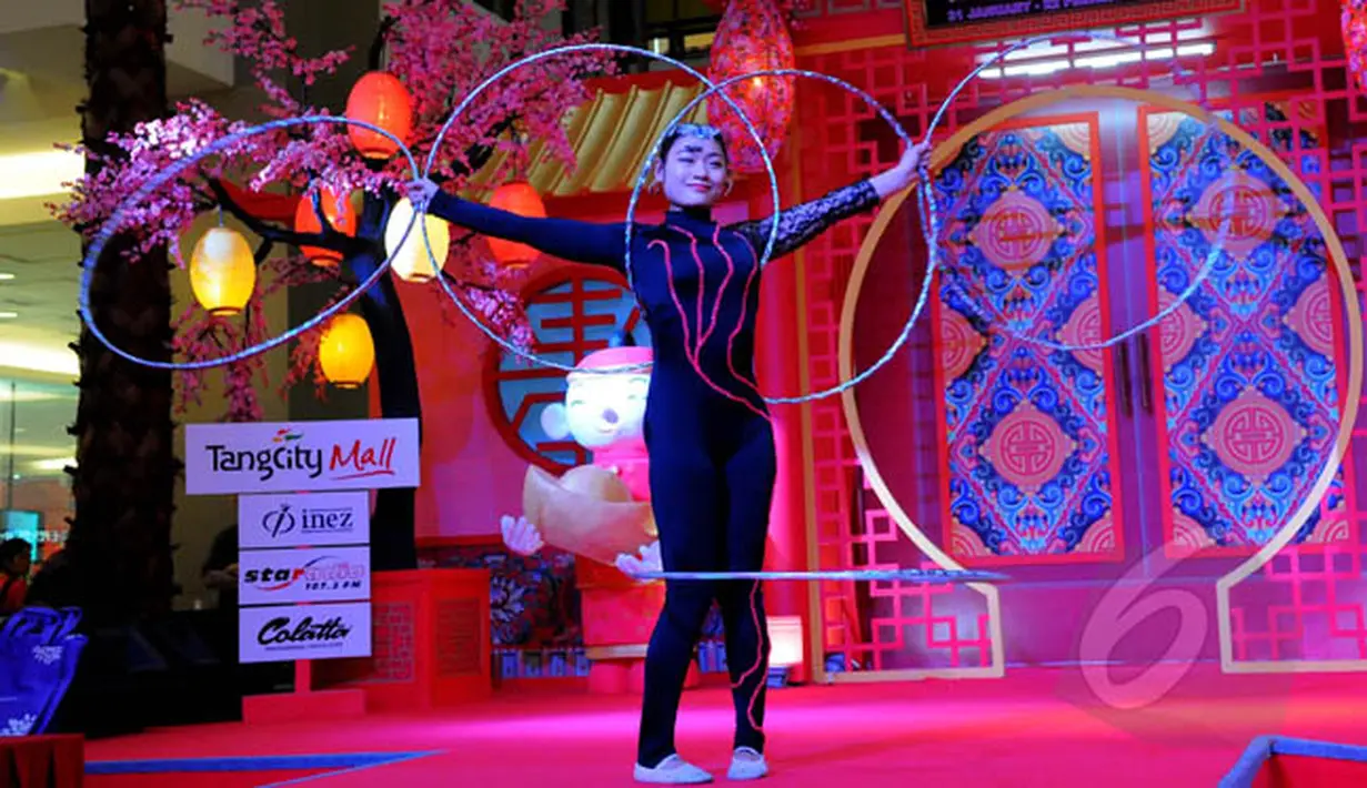 Kelompok seni akrobat asal China bermain hollahop dalam pertunjukan "The Dazzling Duo Chinese Acrobatic Show" di Tangerang City Mall, Tangerang, Jumat (20/2/2015). Pertunjukan akrobat dalam rangka memperingati Imlek 2566. (Liputan6.com/Faisal R Syam) 