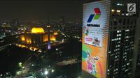 Maskot Asian Games  2018, Atung terpampang di video mapping atau layar bergerak di Gedung Utama Pertamina, Jakarta, Kamis (5/7). Paduan warna dan ukuran raksasa diharapkan menjadi ikon yang memancarkan energi bagi masyarakat. (Liputan6.com/Arya Manggala)