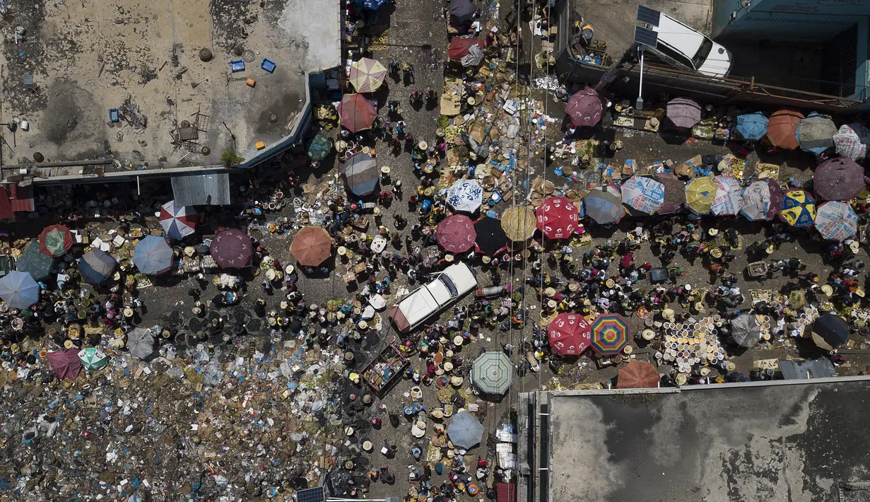 Orang-orang berbelanja di pasar Petion-Ville di Port-au-Prince, empat hari setelah pembunuhan Presiden Haiti Jovenel Moise, Minggu (11/7/2021). Sebelumnya, Presiden Haiti Jovenel Moise tewas dibunuh dalam serangan di kediaman pribadinya, pada Rabu 7 Juli 2021 dini hari. (AP Photo/Matias Delacroix)