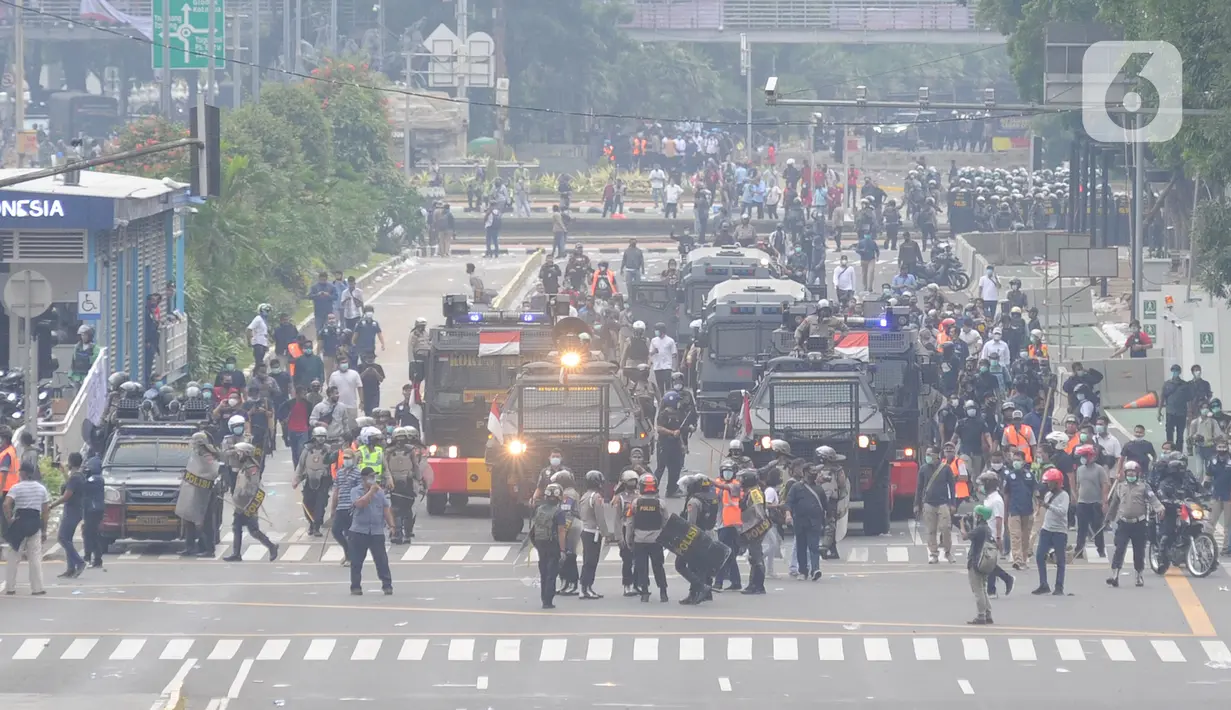 Petugas Brimob Polri menembakkan gas air mata untuk membubarkan massa usai terjadi lemparan batu di Jalan MH Thamrin, Jakarta, Selas (13/10/2020). Massa pengunjuk rasa yang menolak Omnibus Law akhirnya dibubarkan aparat. (merdeka.com/Arie Basuki)