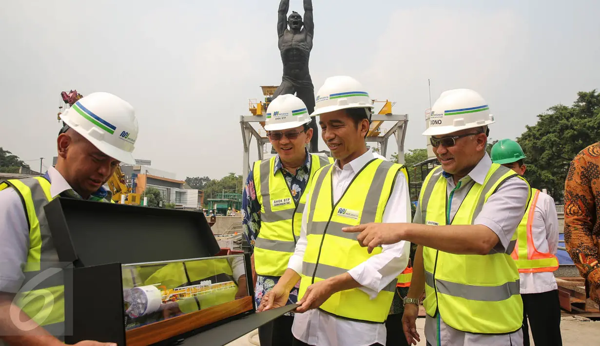 Presiden Jokowi (kedua kanan) melihat maket mesin bor bawah tanah Antareja usai meninjau proses pengeboran proyek terowongan MRT titik lokasi Patung Pemuda, Senayan, Jakarta, Kamis (8/10). (Liputan6.com/Faizal Fanani)