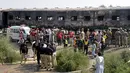 Tentara Pakistan memeriksa kereta yang hangus akibat terbakar di Liaquatpur, Pakistan (31/10/2019). Kebakaran besar melanda tiga gerbong kereta yang bepergian di provinsi Punjab timur negara itu. (AP Photo/Siddique Baluch)