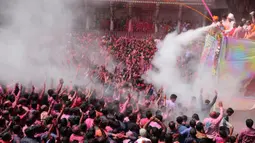 Umat Hindu bersorak ketika bubuk berwarna dan air disemprotkan kepada mereka saat Festival Holi di Kuil Swaminarayan, Ahmedabad, India, Selasa (10/3/2020). Festival Holi menandai datangnya musim semi di India. (AP Photo/Ajit Solanki)