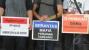 Sejumlah aktivis Koalisi Anti Mafia Tambang membentangkan poster saat menggelar aksi damai di halaman gedung KPK, Jakarta, Jumat (13/3/2015). Mereka menolak adamua dugaan kriminalisasi terhadap lembaga KPK. (Liputan6.com/Herman Zakharia)