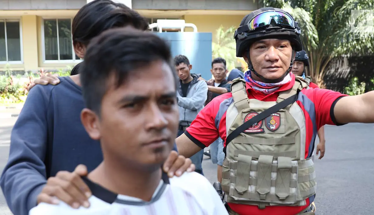 Petugas kepolisian menggiring tersangka yang ditangkap dalam Operasi Cipta Kondisi di Mapolda Metro Jaya, Jakarta, Jumat (6/7). Para tersangka diamankan di wilayah hukum Polda Metro Jaya selama tiga hari. (Liputan6.com/Immanuel Antonius)