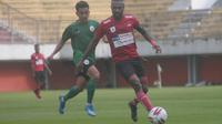 Aksi Striker Persipura Jayapura, Boaz Solossa ditempel ketat pemain PSS Sleman dalam uji coba di Stadion Maguwoharjo, Sabtu (22/2/2020). (Bola.com/Vincentius Atmaja)