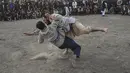 Pria Afghanistan bergulat di latar belakang selama tontonan gulat mingguan yang diadakan di arena darurat di taman Chaman-e-Hozori, di Kota Kabul (12/11/2021). (AFP/Hector Retamal)