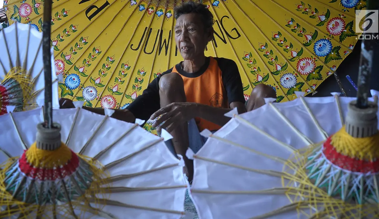 Perajin menyelesaikan pembuatan payung kertas di Desa Tanjung, Kecamatan Juwiring, Klaten, Kamis (11/10). Mereka meneruskan kerajinan payung hias yang merupakan warisan seni pada era 1800-an dari leluhurnya. (Liputan6.com/Gholib)