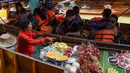 Pedagang buah menawarkan dagangannya kepada wisatawan yang sedang naik kapal di pasar terapung Damnoen Saduak, Bangkok, Thailand, Jumat (21/6/2019). Para pedagang di pasar terapung Damnoen Saduak akan menyusuri sungai untuk menjajakan dagangan kepada wisatawan. (TANG CHHIN Sothy/AFP)