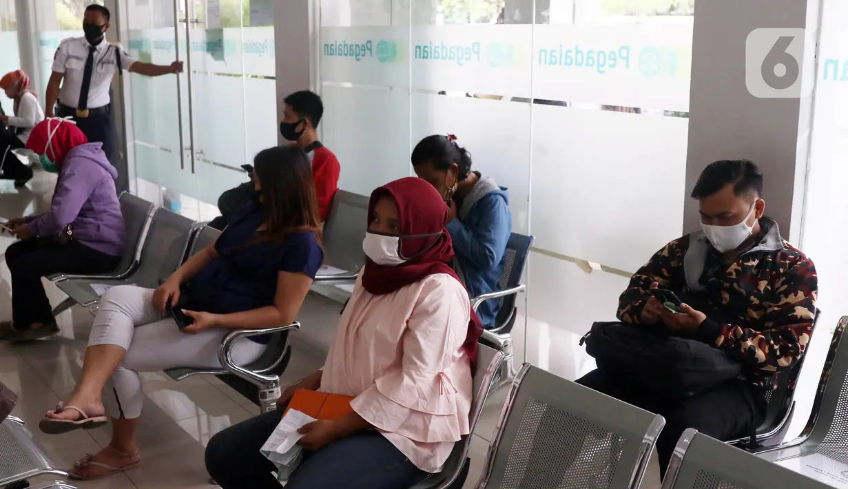 Sejumlah nasabah duduk menjaga jarak fisik saat di Pegadaian Kota Tangerang, Banten, Kamis (4/6/2020). Memasuki tahun ajaran baru yang jatuh pada 13 Juli 2020, warga ramai menggadaikan barang mereka untuk persiapan masuk sekolah anak. (Liputan6.com/Angga Yuniar)