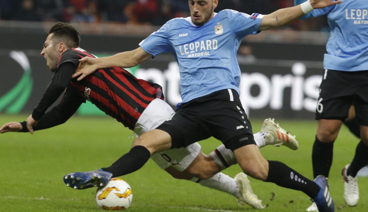 Gelandang AC Milan, Andrea Bertolacci, terjatuh saat berebut bola dengan pemain F91 Dudelange, Edisson Jordan, pada laga Liga Europa di Stadion San Siro, Kamis (29/11). AC Milan menang 5-2 atas F91 Dudelange. (AP/Luca Bruno)