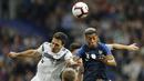 Pemain Prancis, Presnel Kimpembe, duel udara dengan bek Jerman, Mats Hummels, pada laga UEFA Nations League di Stade de France, Paris, Selasa (16/10/2018). Prancis menang 2-1 atas Jerman. (AP/Christophe Ena)