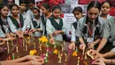 Sejumlah siswa melakukan upacara doa khusus untuk menghormati 39 orang India yang jasadnya ditemukan terkubur di barat laut Mosul, India (21/3). (AP/Channi Anand)