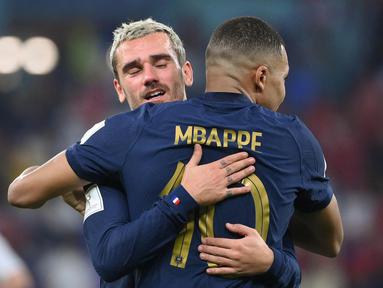 Antoine Griezmann resmi mengumumkan pengunduran dirinya dari sepak bola internasional. Tampak dalam foto, pemain depan timnas Prancis, Antoine Griezmann (kiri) bersama Kylian Mbappe saat merayakan gol pertama timnya selama pertandingan sepak bola Grup D Piala Dunia Qatar 2022 melawan Denmark di Stadion 974 di Doha pada 26 November 2022. (FRANCK FIFE/AFP)