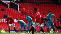 Penyerang Manchester United (MU), Marcus Rashford saat mengeksekusi penalti ke gawang Bournemouth di Old Trafford, Sabtu (4/7/2020). (Clive Brunskill/Pool via AP)