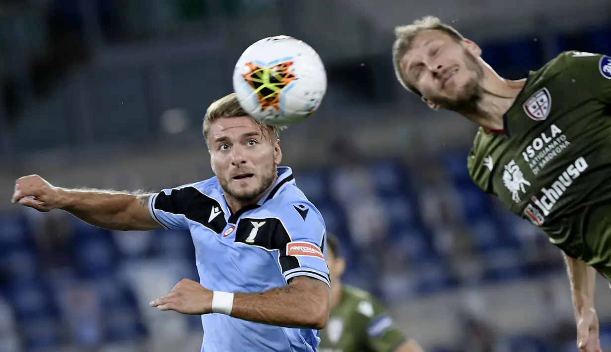 Penyerang Lazio, Ciro Immobile, berebut bola dengan bek Cagliari, Ragnar Klavan, pada laga lanjutan Serie A pekan ke-35 di Stadio Olimpico, Jumat (24/7/2020) dini hari WIB. Lazio menang 2-1 atas Cagliari.(AFP/Filippo Monteforte)