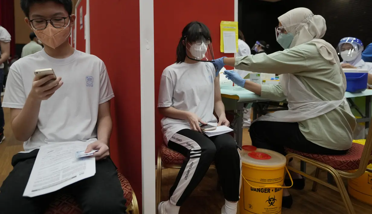 Seorang siswa sekolah menengah menerima dosis vaksin Pfizer terhadap penyakit coronavirus (COVID-19) di pusat vaksin di Shah Alam, Malaysia, Senin (20/9/2021). (AP Photo/Vincent Thian)