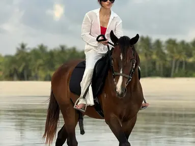 Penampilan Pevita Pearce saat menunggang kuda terlihat kece. Lewat pakaian bernuansa putih, Pevita tampil anggun menunggangi kuda bernama Kayu. (Liputan6.com/IG/@pevpearce)
