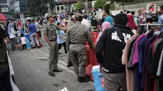 Satpol PP DKI Jakarta menertibkan PKL yang berdagang di kawasan Car Free Day, Bundaran HI, Jakarta, Minggu (20/1). Penertiban dilakukan karena telah membuat ketidaknyamanan bagi para pengunjung CFD yang ingin berolahraga. (Liputan6.com/Faizal Fanani)