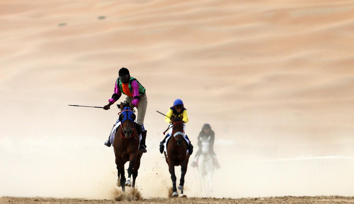 Para joki beraksi dalam lomba balap kuda Festival Moreeb Dune 2016 di gurun Liwa, 250 km barat Abu Dhabi. (AFP/Karim Sahib)