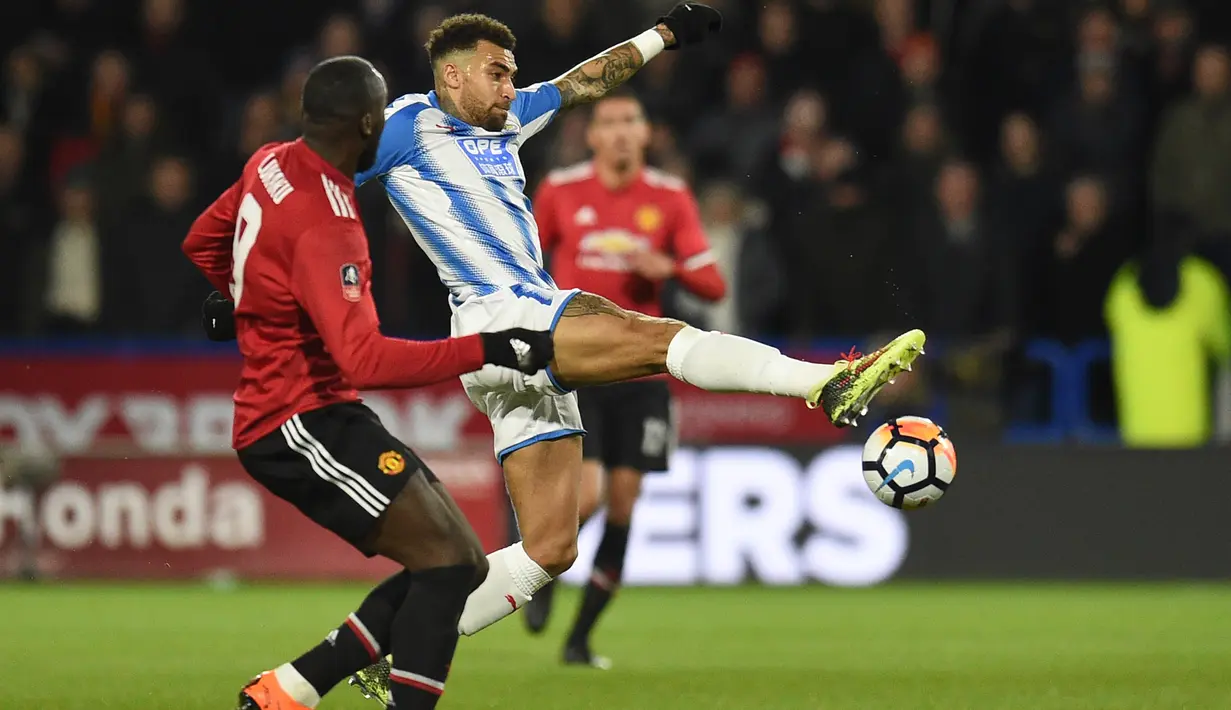 Pemain Huddersfield, Danny Williams membuang bola dari kejaran Romelu Lukaku (kiri) pada putaran kelima Piala FA di John Smith stadium, Huddersfield, (17/2/2018). Manchester United menang 2-0. (AFP/Oli Scarff)
