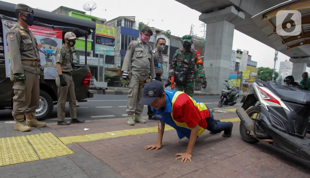 Petugas gabungan memberikan hukuman push up kepada warga yang tidak memakai masker saat razia Pembatasan Sosial Berskala Besar (PSBB) di Kawasan Jalan Fatmawati, Jakarta, Selasa (28/4/2020). Penertiban terkait pelaksanaan PSBB Jakarta dan memutus rantai penyebaran COVID 19. (merdeka.com/Imam Buhori)