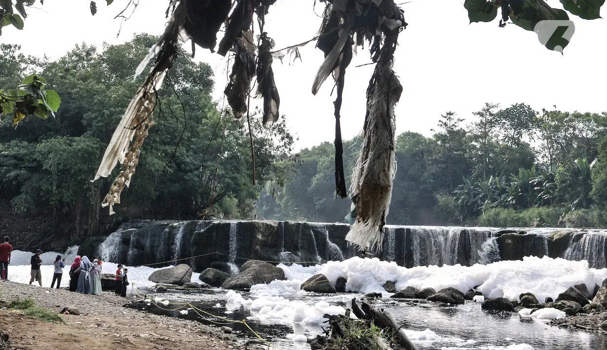 Wisatawan mengunjungi Curug Parigi yang tengah tercemar limbah busa di Cikiwul, Bantargebang, Bekasi, Jawa Barat, Minggu (19/7/2020). Meski begitu, sejumlah wisatawan tetap ramai mengunjungi Curug Parigi walaupun hanya sebentar. (merdeka.com/Iqbal S. Nugroho)