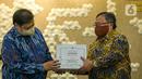 Menristek Bambang Brodjonegoro (kanan) memberikan GeNose C19 kepada Menko Bidang Perekonomian Airlangga Hartarto di Gedung Kemenko Perekonomian, Jakarta, Senin (22/3/2021). GeNose C19 diharapkan dapat semakin dikenal dan dimanfaatkan secara lebih masif. (Liputan6.com/Faizal Fanani)