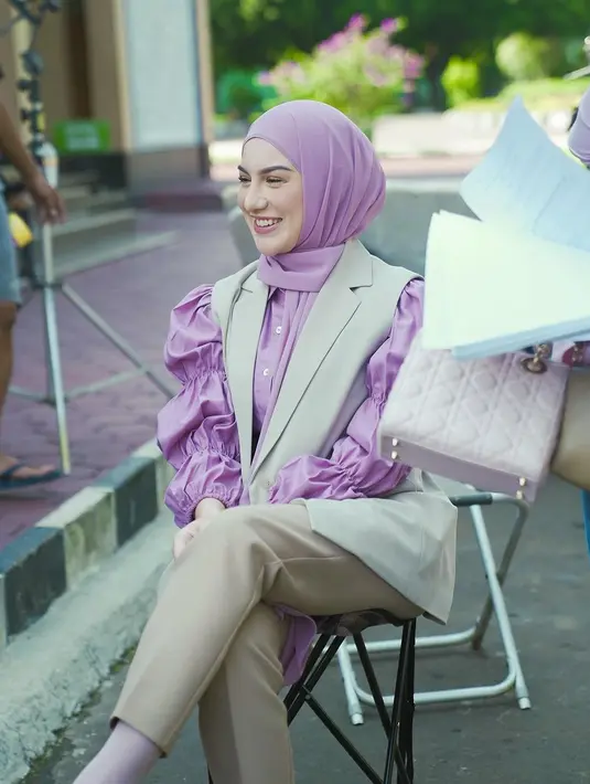 Lalu, ia menumpuknya dengan outer vest dan celana panjang cokelat yang senada. [Foto: Instagram/_irishbella_]